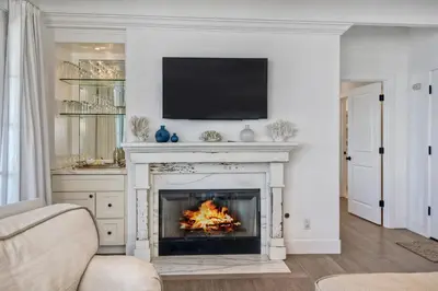 a living room with a fireplace with a tv above it at Juniper Beach Entire Home - Sleeps 18 - Oceanfront in Carlsbad