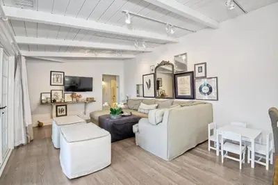 a living room with white furniture and a table at Juniper Beach Entire Home - Sleeps 18 - Oceanfront in Carlsbad