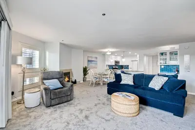 a living room with a blue couch and a chair at Ocean View, Pool, Hot Tub, Steps To Pier, Gated in Oceanside