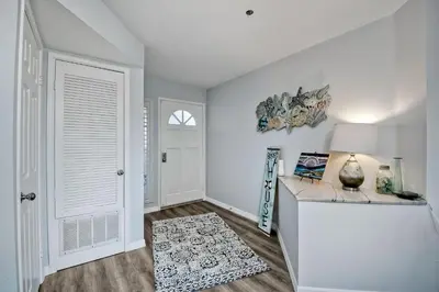 a white room with a white door and a table at Ocean View, Pool, Hot Tub, Steps To Pier, Gated in Oceanside