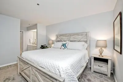 a white bedroom with a large bed and a lamp at Ocean View, Pool, Hot Tub, Steps To Pier, Gated in Oceanside