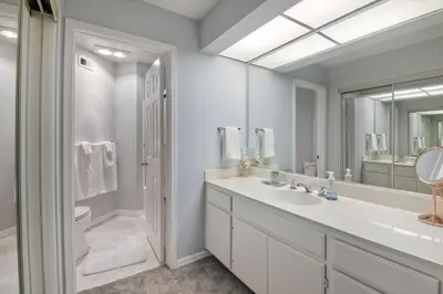 a white bathroom with a sink and a mirror at Ocean View, Pool, Hot Tub, Steps To Pier, Gated in Oceanside