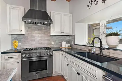 a kitchen with a stainless steel stove and a sink at Rooftop Oceanview Patio - 5BR Remodeled Home in Carlsbad