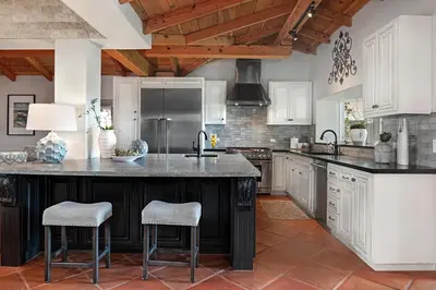a kitchen with a large kitchen island with two bar stools at Rooftop Oceanview Patio - 5BR Remodeled Home in Carlsbad