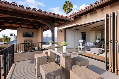a patio with two tables and chairs on a balcony at Rooftop Oceanview Patio - 5BR Remodeled Home in Carlsbad
