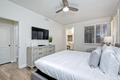 a white bedroom with a bed and a ceiling fan at Lagoon Views - Pool - Hot Tub - Gated Community in Carlsbad