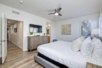 a bedroom with a white bed with a ceiling fan at Lagoon Views - Pool - Hot Tub - Gated Community in Carlsbad