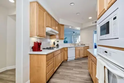 a kitchen with wooden cabinets and white appliances at Lagoon Views - Pool - Hot Tub - Gated Community in Carlsbad