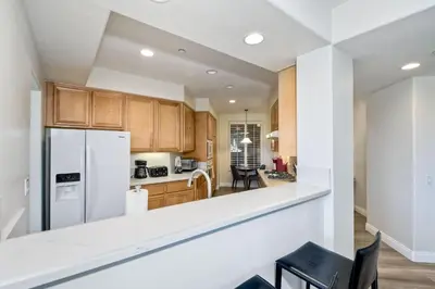 a kitchen with wooden cabinets and a white refrigerator at Lagoon Views - Pool - Hot Tub - Gated Community in Carlsbad