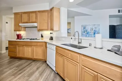 a kitchen with wooden cabinets and white appliances at Lagoon Views - Pool - Hot Tub - Gated Community in Carlsbad
