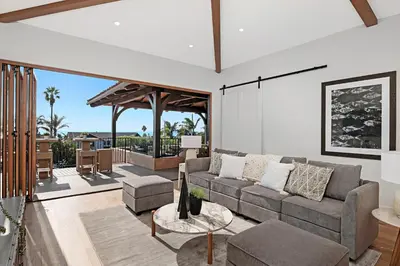 a living room with a couch and a patio at Oceanview Rooftop Patio - Walk To The Beach & Park in Carlsbad