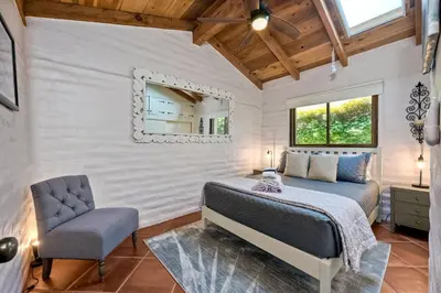 a bedroom with a bed and a chair and a mirror at Walk To The Beach - Outdoor Dining - Spacious in Carlsbad