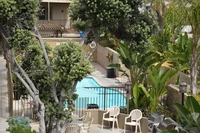 a resort with a pool and chairs and trees at Aquamarine Villas in Oceanside
