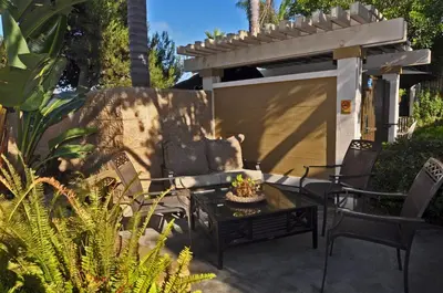 a patio with a couch and chairs and a table at Aquamarine Villas in Oceanside