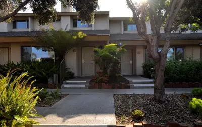 a house with trees and plants in front of it at Aquamarine Villas in Oceanside