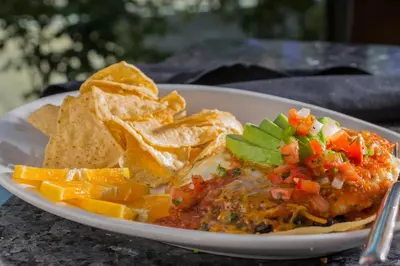 a plate of food with salsa and chips on a table at Holiday Inn Carlsbad/San Diego by IHG in Carlsbad