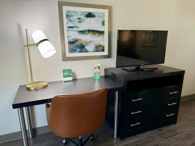 a desk with a television and a lamp and a chair at Holiday Inn Carlsbad/San Diego by IHG in Carlsbad