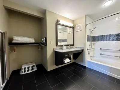 a bathroom with a sink and a tub and a mirror at Staybridge Suites Carlsbad/San Diego by IHG in Carlsbad