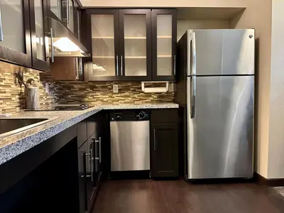 a kitchen with a stainless steel refrigerator and cabinets at Staybridge Suites Carlsbad/San Diego by IHG in Carlsbad