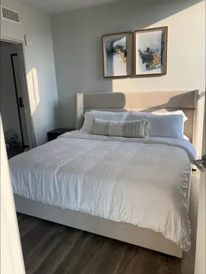 a bed with white sheets and pillows in a bedroom at Modern 2-Bedroom Apartment in Little Italy in San Diego