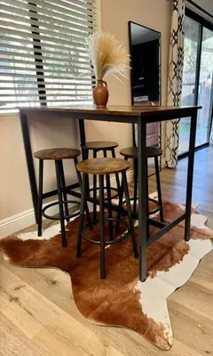a black table with stools and a vase on top at San Diego Trail Guest Ranch in Poway