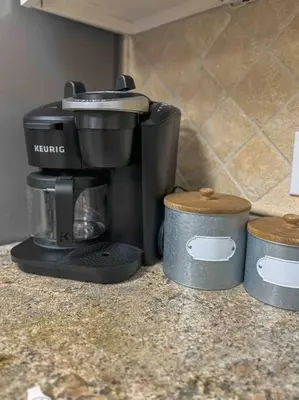 a coffee maker on a counter next to two containers at San Diego Trail Guest Ranch in Poway