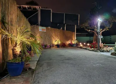 a walkway with potted plants and a fence at night at * - The Leucadia Beach Grotto - * An Encinitas Gem in Encinitas