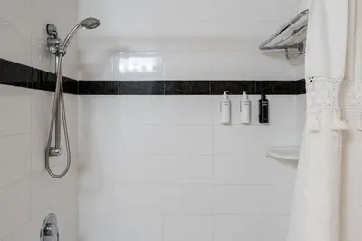 a white bathroom with a shower and a sink at Sur La Mer, beachfront, tidal pools in San Diego