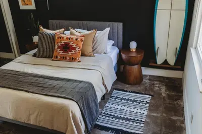 a bedroom with two beds and a surfboard on the wall at Casa de Vaqueros! Family&Pet Friendly! 3mi to the Beach! in San Juan Capistrano