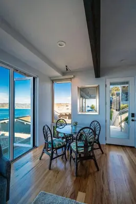 a dining room with a table and chairs and windows at Oceanfront Studio in Heart of La Jolla Cove in San Diego