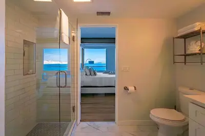 a bathroom with a shower and a toilet and a bedroom at Oceanfront Studio in Heart of La Jolla Cove in San Diego