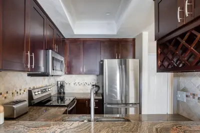 a kitchen with wooden cabinets and a stainless steel refrigerator at Blueground Mission Valley w gym pool SAN-43 in San Diego