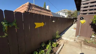 a fence with a yellow arrow on it at Walking Distance to Little Italy in San Diego