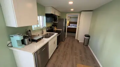 a small kitchen with a sink and a refrigerator at Walking Distance to Little Italy in San Diego