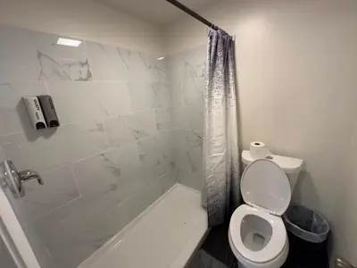 a white bathroom with a toilet and a shower at Walking Distance to Little Italy in San Diego