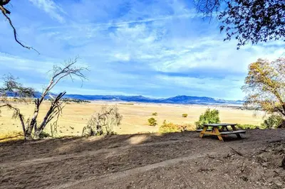 a picnic table in the middle of a field at #3 Howling Wolf's Lair - Cabin W/Fireplace & Views in Santa Ysabel