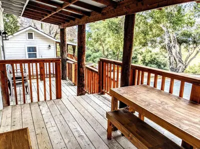 a wooden porch with a wooden bench on a deck at #7 Josie's Mountain Top Hideout-Cabin in the Woods in Santa Ysabel