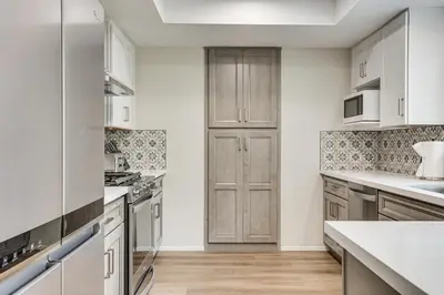 a kitchen with white cabinets and white counter tops at Sunny Oceanside Home with Patio, 5 Mi to Downtown! in Oceanside