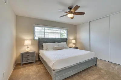 a bedroom with a bed and a ceiling fan at Sunny Oceanside Home with Patio, 5 Mi to Downtown! in Oceanside