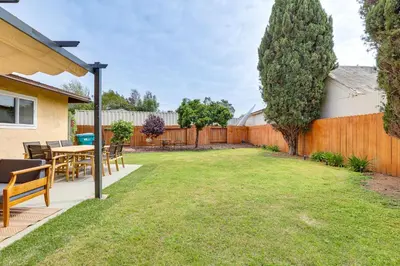a backyard with a table and chairs and a fence at Sunny Oceanside Home with Patio, 5 Mi to Downtown! in Oceanside