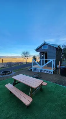 a picnic table and a bench in front of a shed at #13 - The Raven - Tiny Home (Edgar Allan Poe) in Santa Ysabel