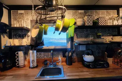 a kitchen counter with a sink and a tv on the wall at #13 - The Raven - Tiny Home (Edgar Allan Poe) in Santa Ysabel