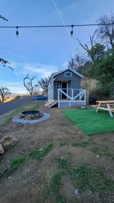 a small shed with a bench and a picnic table at #13 - The Raven - Tiny Home (Edgar Allan Poe) in Santa Ysabel