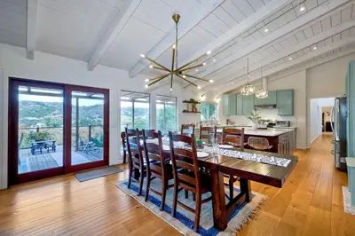 a dining room and kitchen with a table and chairs at City Getaway, Hot Tub, Fire Pit, Game Room, BBQ, Hiking Trails, Vineyard Views, B-Ball in Fallbrook