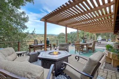 a patio with a wooden pergola and a table and chairs at City Getaway, Hot Tub, Fire Pit, Game Room, BBQ, Hiking Trails, Vineyard Views, B-Ball in Fallbrook