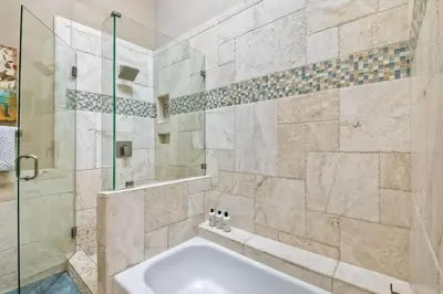 a bathroom with a tub and a glass shower at Oceanfront, Luxury Remodel, Pool, Walk To Dining in Encinitas