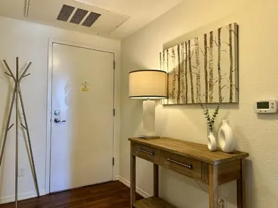 a hallway with a table with a lamp and a door at SPECIAL OFFER - Modern Apartment in La Jolla UTC - Close to Beaches, Shopping, Dining, UCSD in San Diego