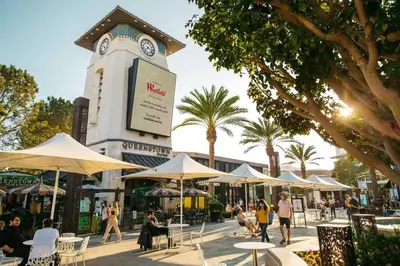 a building with a clock tower with tables and chairs at SPECIAL OFFER - Modern Apartment in La Jolla UTC - Close to Beaches, Shopping, Dining, UCSD in San Diego