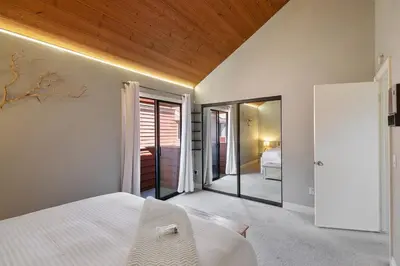 a bedroom with a white bed and a mirror at IB Coastal Condo - Imperial Beach - Shops - Patio in Imperial Beach
