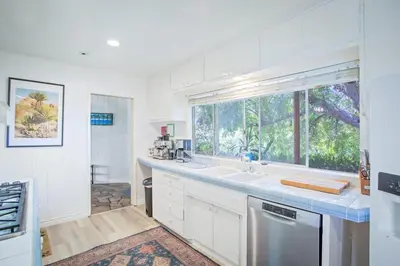 a kitchen with a sink and a large window at Nature lovers wellness home in Fallbrook